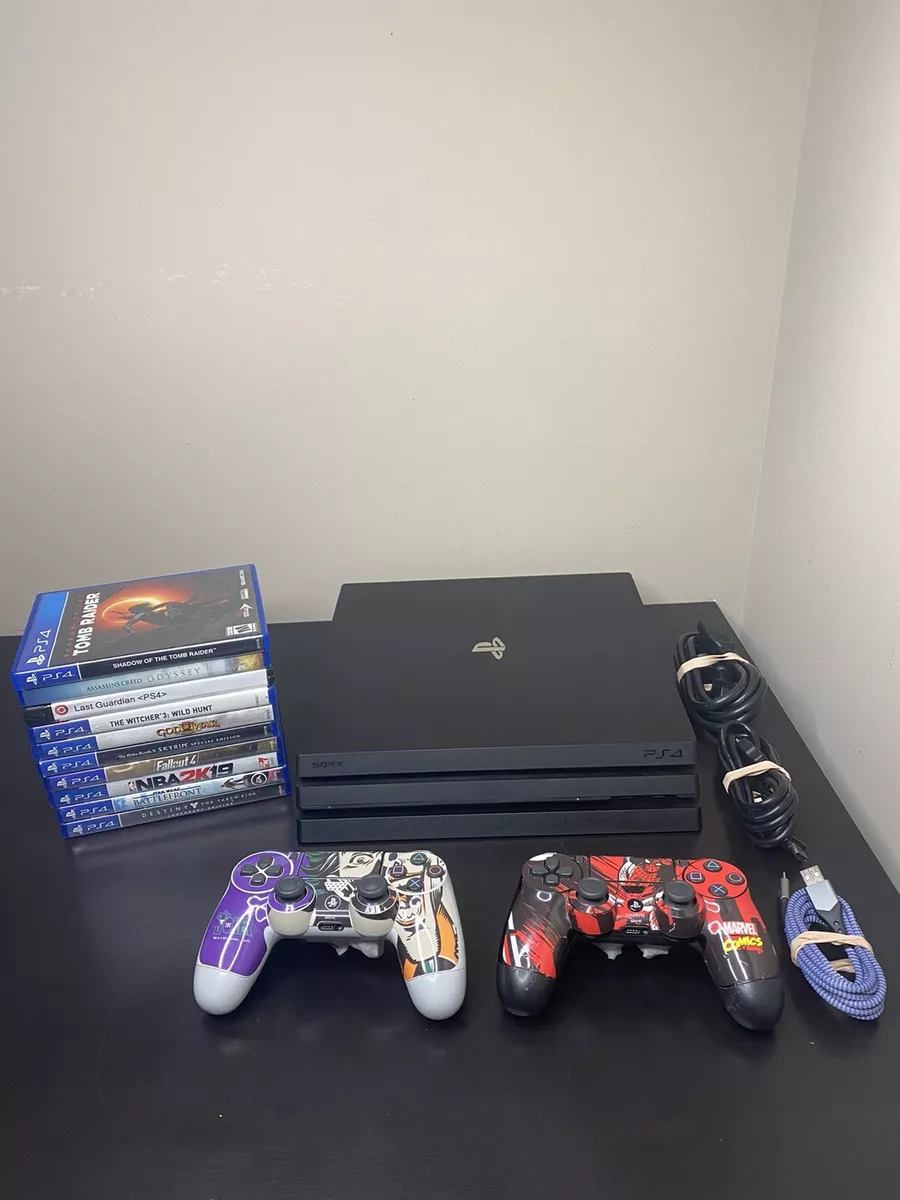 Sony Play Station 4 Pro Gaming Console On The Table With Two