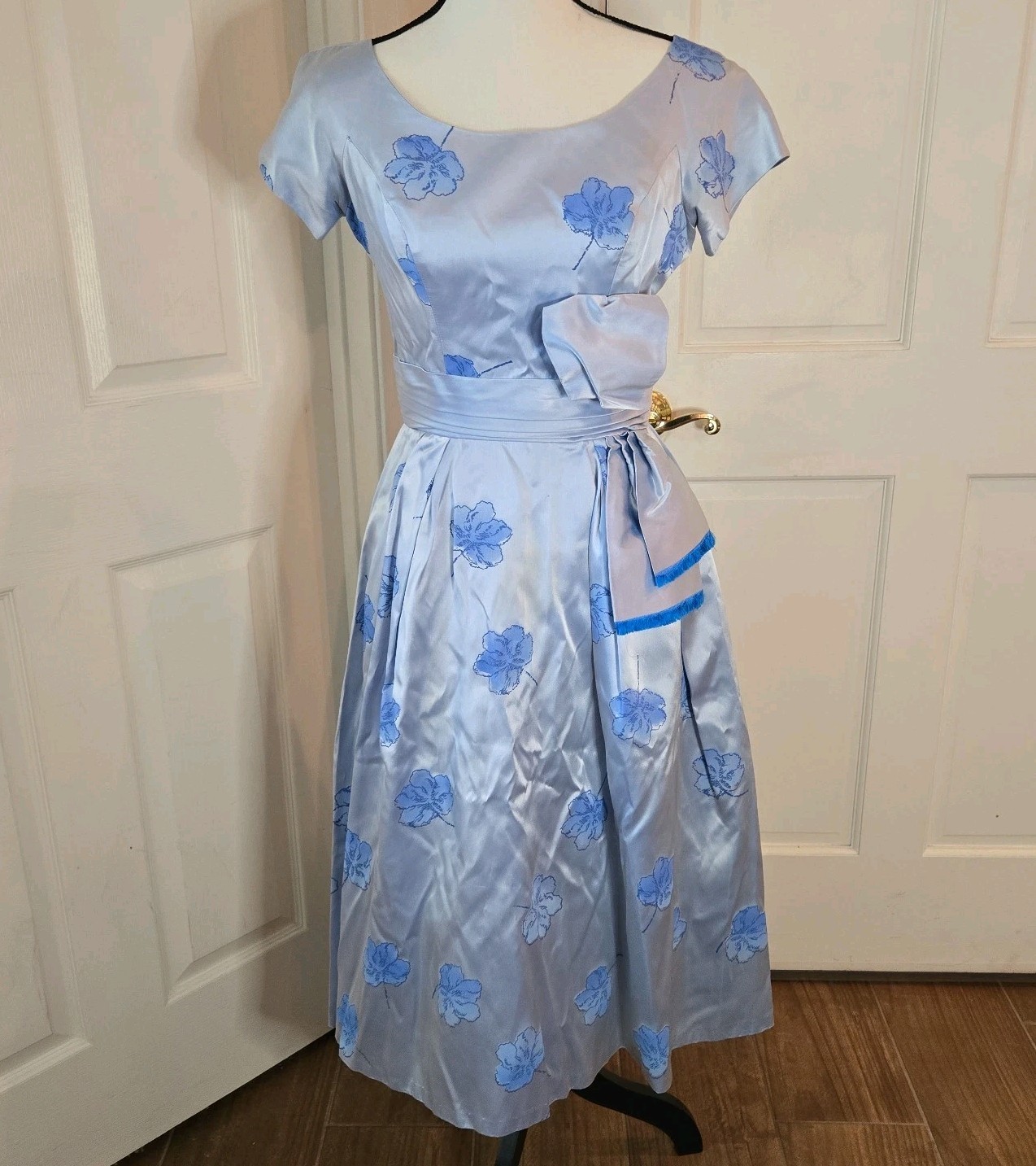 Powder blue floral satin party dress with a bow at the hip.