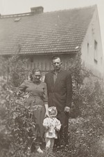 Stolze Eltern stehen mit süßem Mädchen vor Bauernhaus Familie Frau Mann Foto