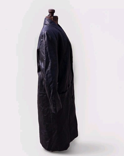 Black vintage leather trench coat with flap pockets, buttons, and shoulder pads displayed on mannequin.