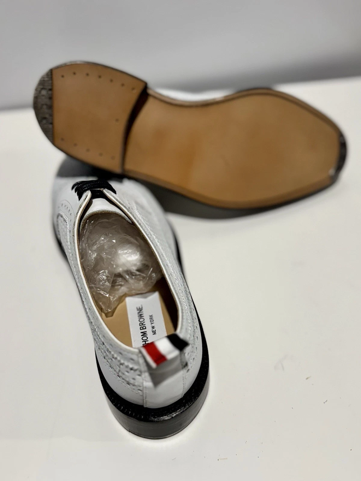 Brogue Thom Browne ala lunga con pelle alcuni e pelle di vitello morbida traforata.