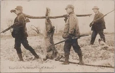 RPPC Postcard Exaggeration Men Hunting Big Guns Carrying Huge Rabbit 