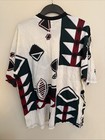 White vintage T-shirt with black, green, red, and black diamond geometric pattern, made in USA.