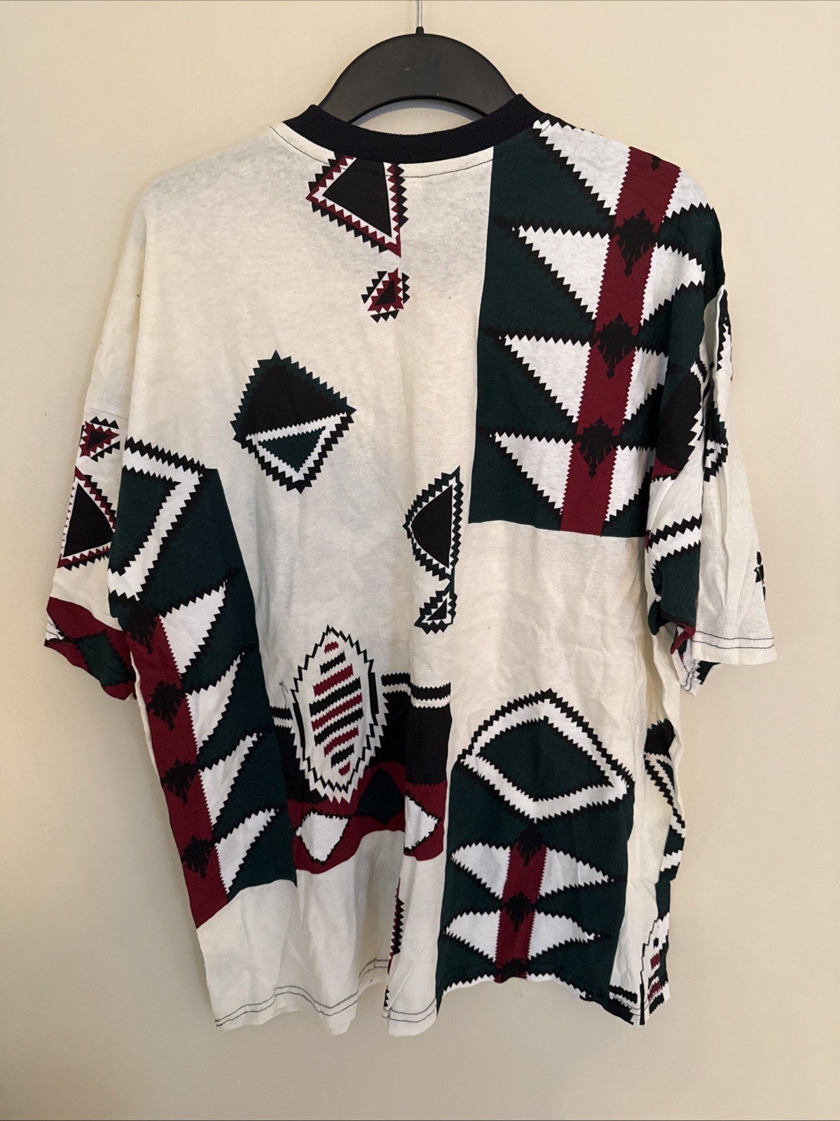 White vintage T-shirt with black, green, red, and black diamond geometric pattern, made in USA.