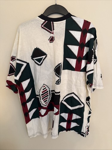White vintage T-shirt with black, green, red, and black diamond geometric pattern, made in USA.