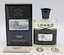 Creed Aventus 120ml bottle with black cap, black box, and two oval portraits of historical figures.