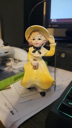 Used Little Bo Peep yellow dress mini porcelain doll with chain. 4.5" in height