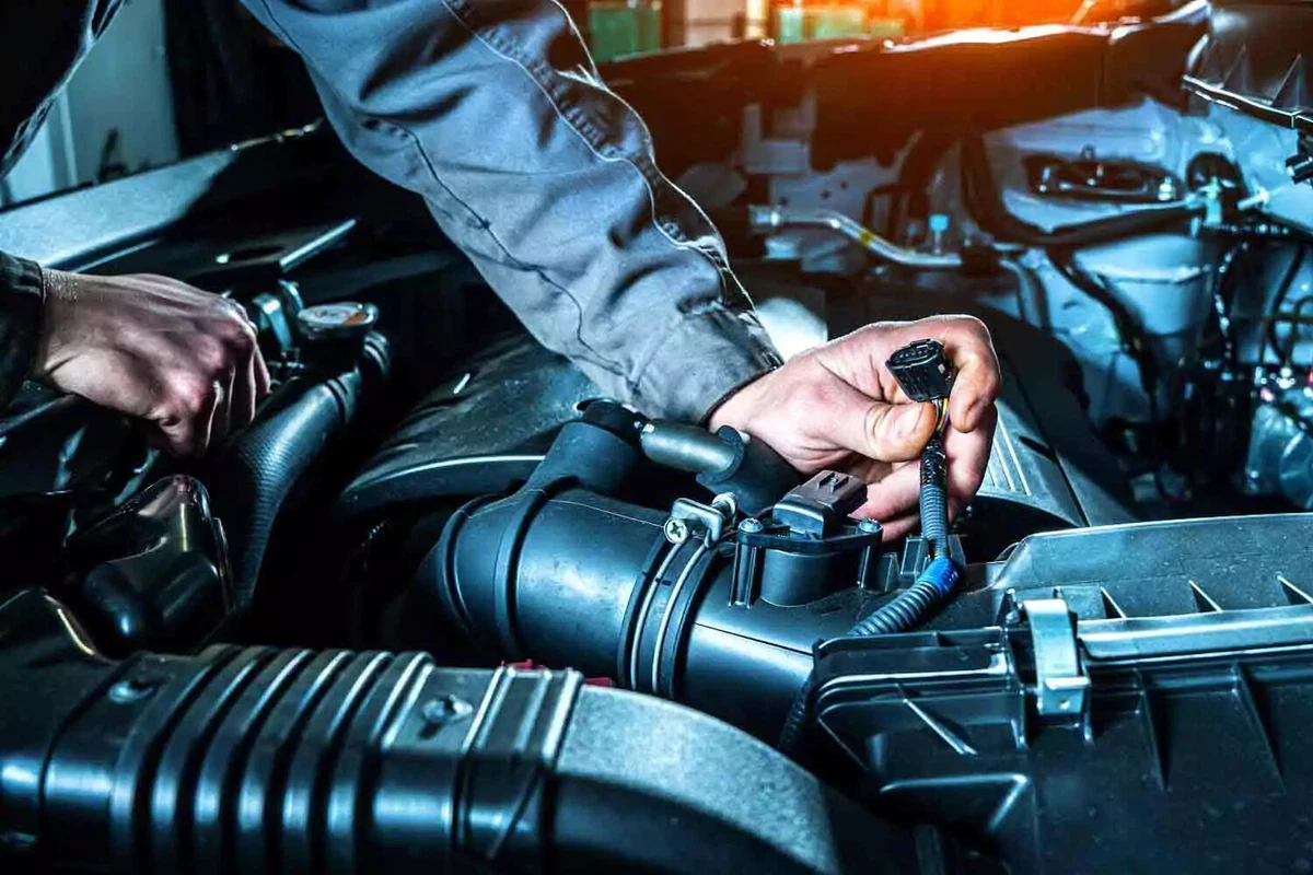A mechanic disconnecting the MAF sensor lead.