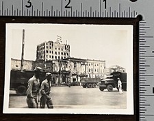 WWII PHOTO SHOWING ARMY TRUCKS, SOLDIERS AND DESTROYED BUILDING IN BACKGROUND