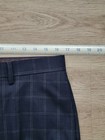 Navy blue plaid men’s flat front dress pants, size 32W x 30L, with white cuff and placket buttons, laid flat on wooden surface.
