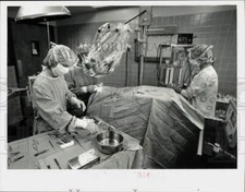 1983 Press Photo Dr. Alfred Hutt performs eye surgery with operating microscope.