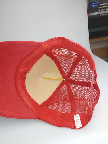 Red and white vintage trucker hat with black mesh front, tan interior lining, and “USA MADE” text on white tag.