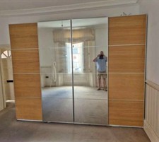 Wardrobe with 3 sliding doors: one is a full mirror, other two are wooden doors