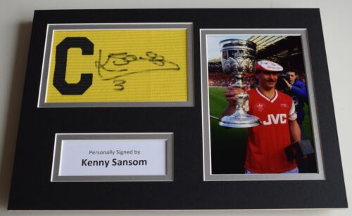 Kenny Sansom SIGNED Captains Armband A4 Photo Display Arsenal AFTAL PROOF & COA - Afbeelding 1 van 8