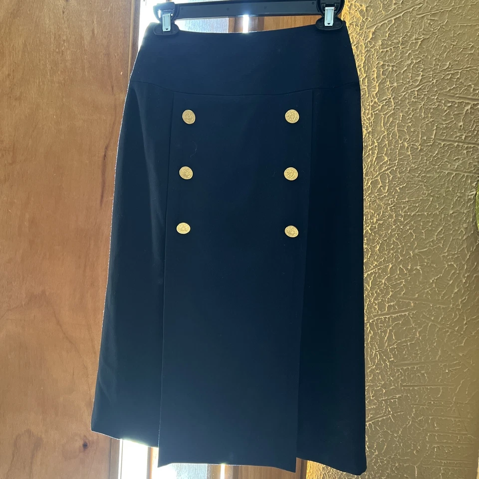 Falda Celine Box plisada de inspiración náutica con botones dorados. Talla 36