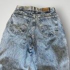 Back view of 90s vintage Lee High Rise Mom Jeans in blue distressed denim with two pockets and brown leather patch on waistband.