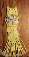 handmade yellow nursery macrame hanger picture with booties and rocking horse