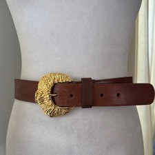 Brown leather belt with a large ornate gold-toned textured buckle