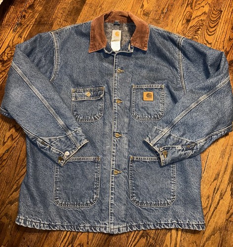 Blue denim Carhartt C59 chore coat with brown collar, front buttons, and small yellow Carhartt logo patch on chest.