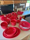 Red fiestaware dinner plates set with a set of matching glasses. No chips