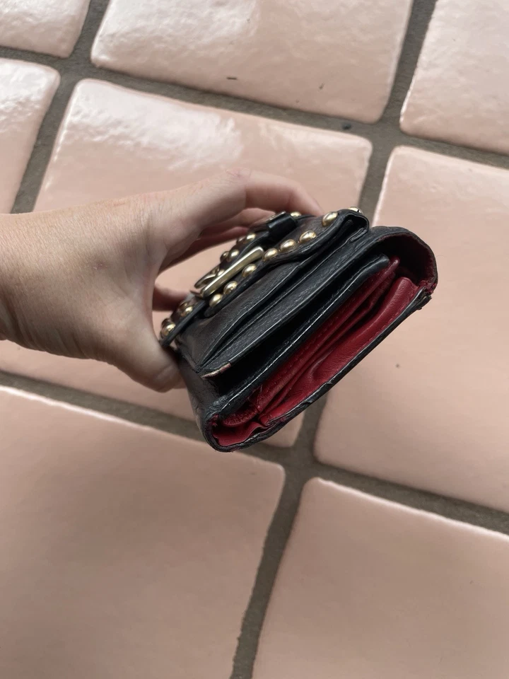 Cartera sin asas Isabella Fiore de cuero negra con tachuelas doradas triple pliegue Foto 2 de 4