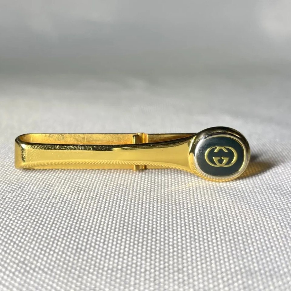 A genuine vintage Gucci GG logo tie bar in gold and black — understated flex for someone who knows what they're looking at.