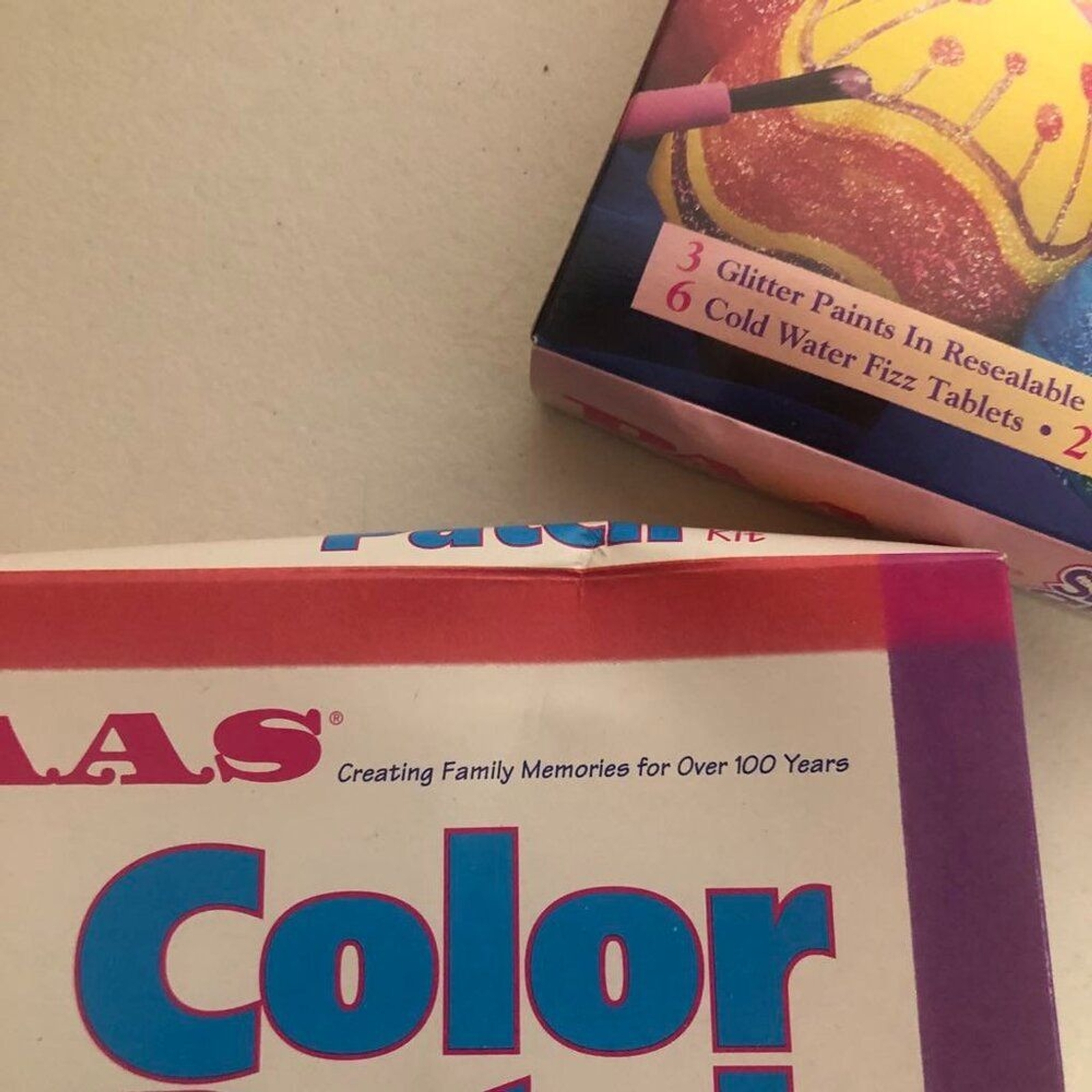 White vintage PAAS Egg Color Set box with glitter patch instructions, pink/purple cake mix, and colorful sprinkles.