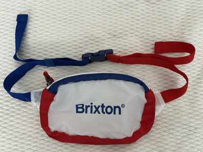 Brixton adjustable strap pouch. New without tags. Color: red/white/blue.