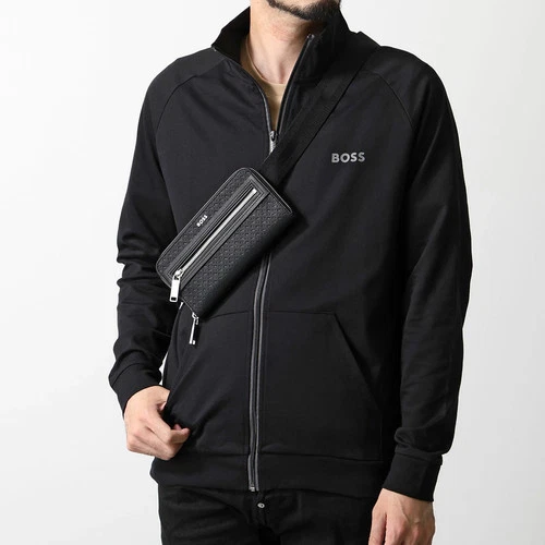 Black HUGO BOSS Daxter MP crossbody bag with silver metal logo, front zipper pocket, and elastic strap.