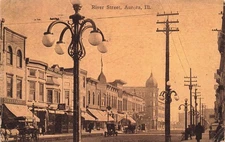 1913 ILLINOIS PHOTO POSTCARD: SCENE OF PEOPLE ON RIVER ST. HOTEL GRAND AURORA IL