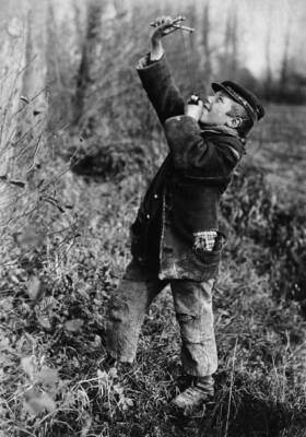 Small boy in ragged clothing aims a catapult into the air 1915 OLD PHOTO