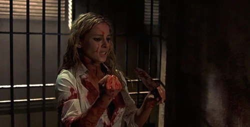 BEYOND RE-ANIMATOR DVD cover: woman in white shirt, red arms, reaching toward prison bars.