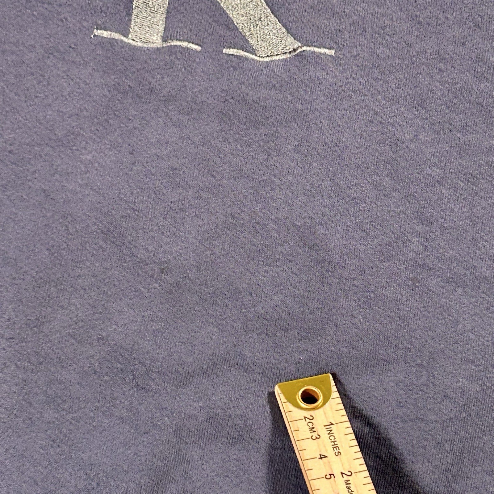 Gray fabric Calvin Klein jeans sweatshirt with gold “C” logo, measurement in yellow ruler, USA Made tag at collar.