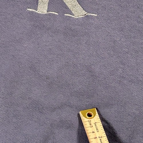 Gray fabric Calvin Klein jeans sweatshirt with gold “C” logo, measurement in yellow ruler, USA Made tag at collar.