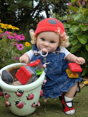 Reborn Baby Doll. With Blue Eyes, Blonde Curly hair and pierced ears. 