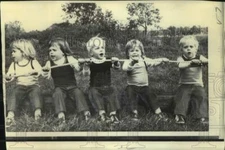 1973 Press Photo Kienast quints sit on log and pull rope in Liberty Corners, NJ