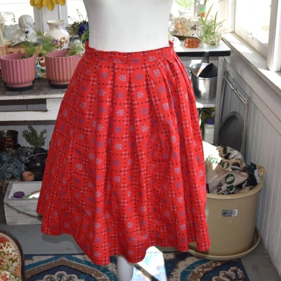 A genuine 1960s red cotton circle skirt with novelty print — a wearable slice of mid-century style that's both functional and a true vintage find.