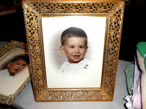 a vintage gold ornate picture frame with a photo of a child.