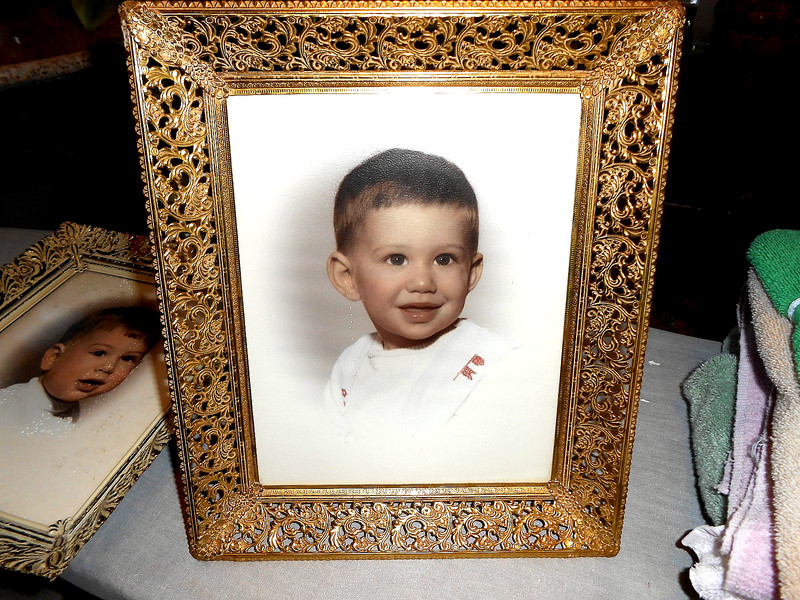 a vintage gold ornate picture frame with a photo of a child.