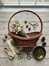 vintage woven brown wicker harvest basket with a single handle oval open top