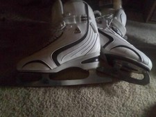 2 pair of ice skates white and the other pair are black and white