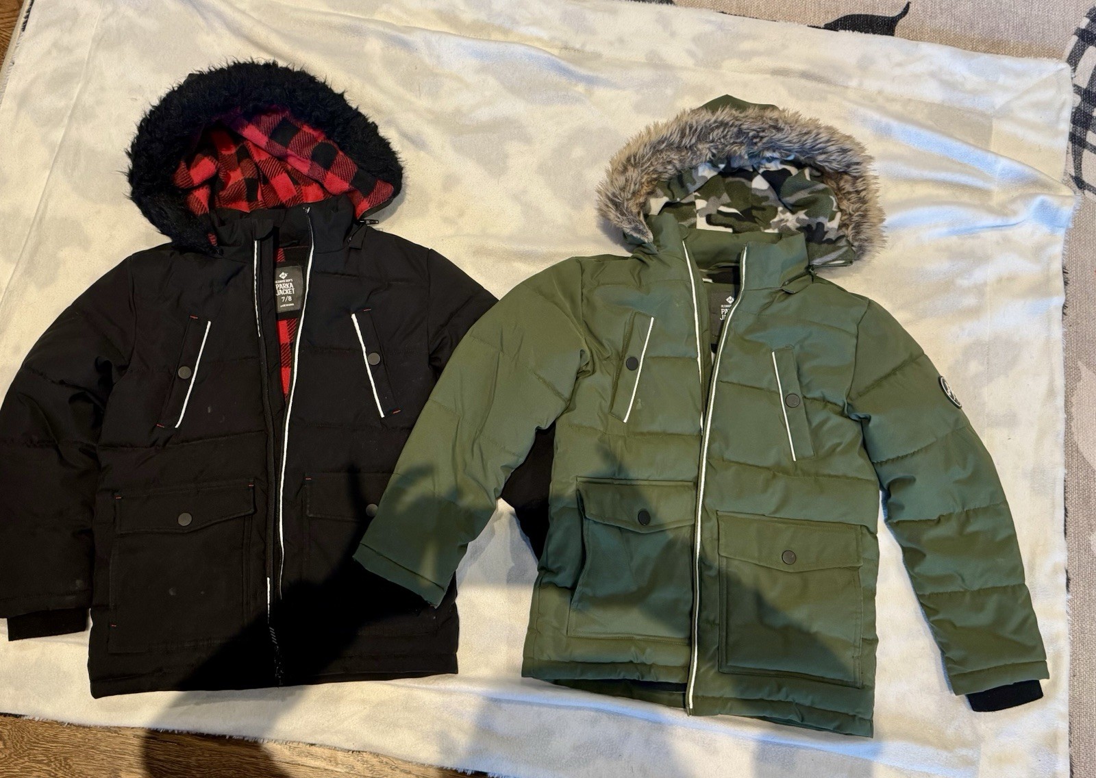 Two Size 7/8 Boys Ultimate Parka jackets, one in black and o
