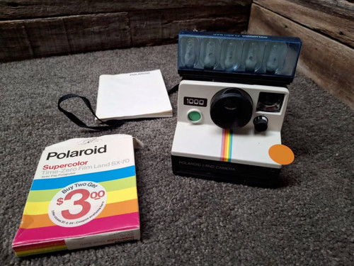 Vintage Polaroid 1000 camera with flash bar and manual