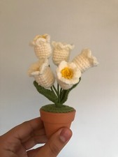 Handmade white and yellow crotchet flowers in a brown clay pot