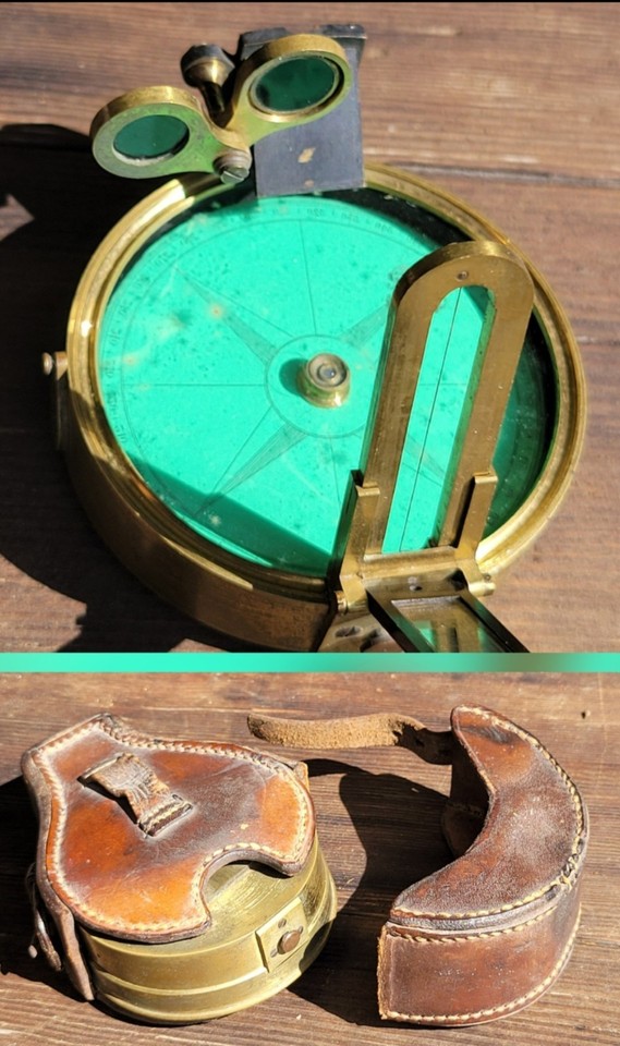 A Troughton & Simms-style prismatic surveying compass in its original leather case — a beautifully precise Victorian-era navigation instrument that doubles as desk art.