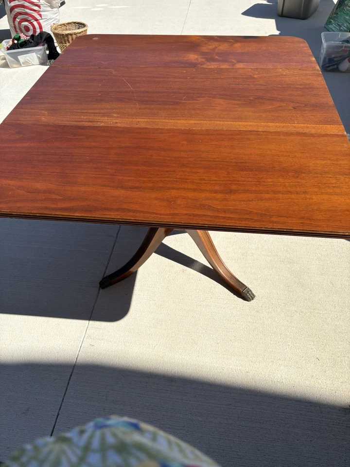 Antigua mesa con patas de madera con hojas caídas con un cajón. Foto 4 de 4