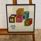 needlepoint picture, monogram signed amb 69, Laura toy blocks, framed
