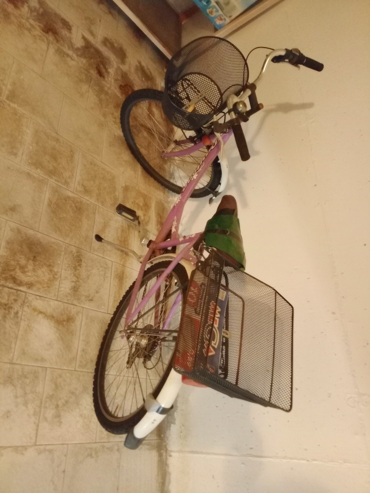 Bicicletta da città rosa con cestino anteriore e portapacchi/cestino posteriore
