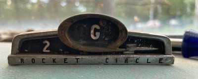 VINTAGE 1956 OLDSMOBILE ROCKET CIRCLE EMBLEM OFF THE CENTER OF MY DASH