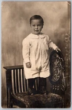 Postcard RPPC Cute Young Child In White Standing On Chair Studio Photo CYKO AS1G